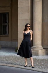 a lady wears a black spaghetti strap midi dress